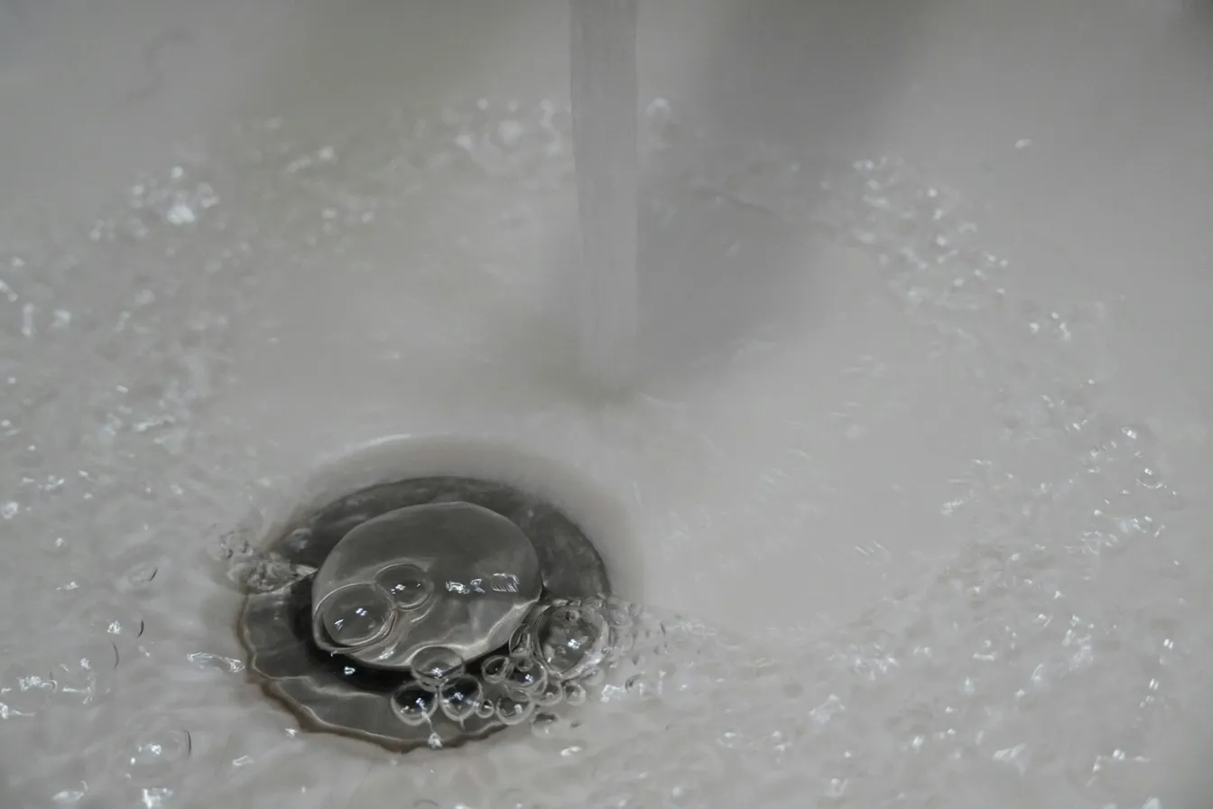 Agua corriendo hacia la coladera de un lavabo