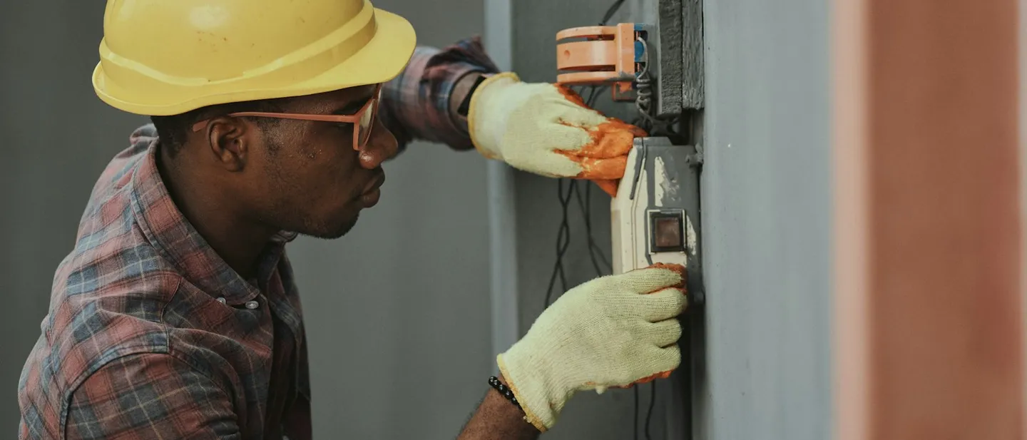 Electricista con casco amarillo instalando cableado