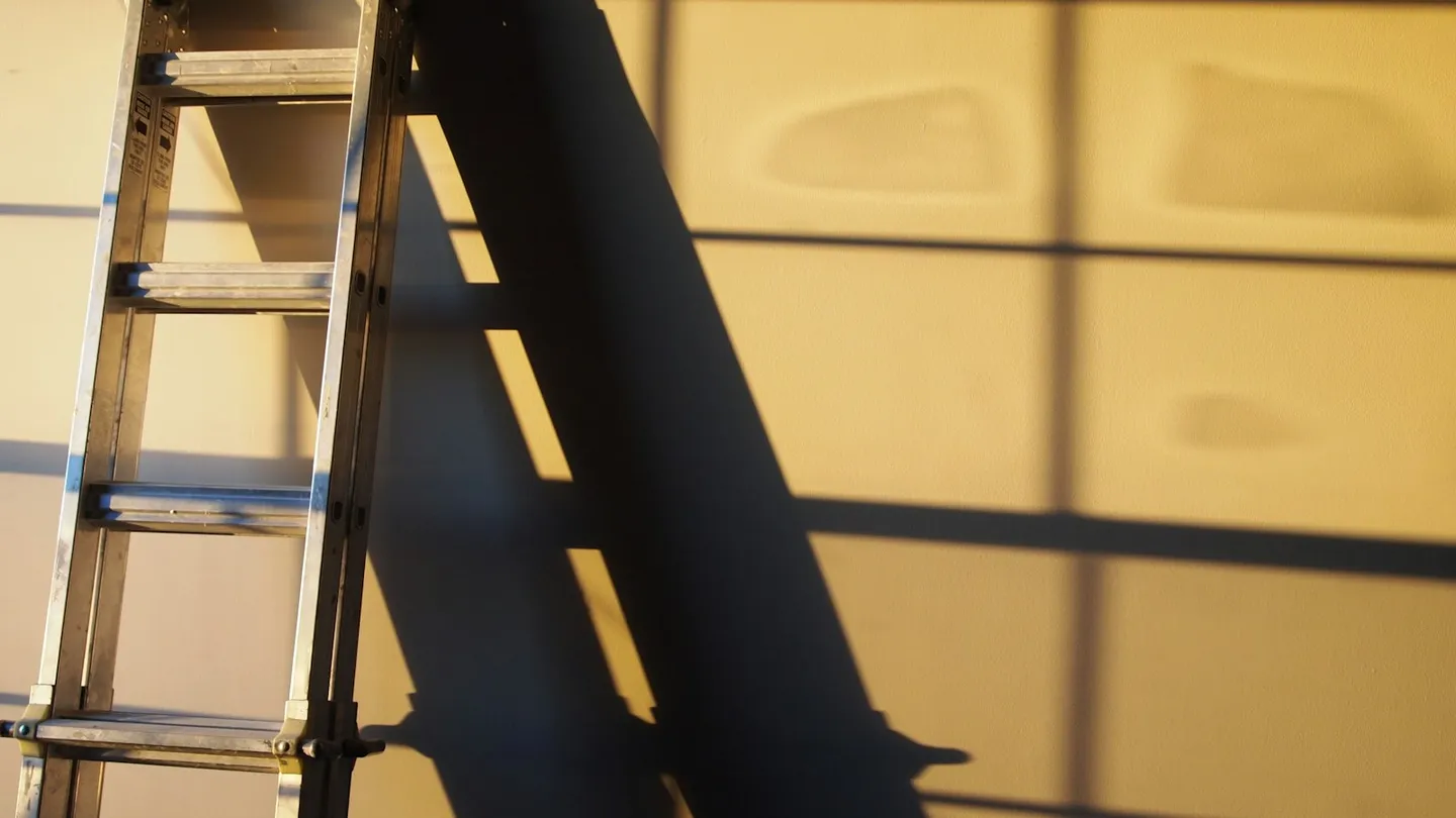 Escalera metálica apoyada en una pared