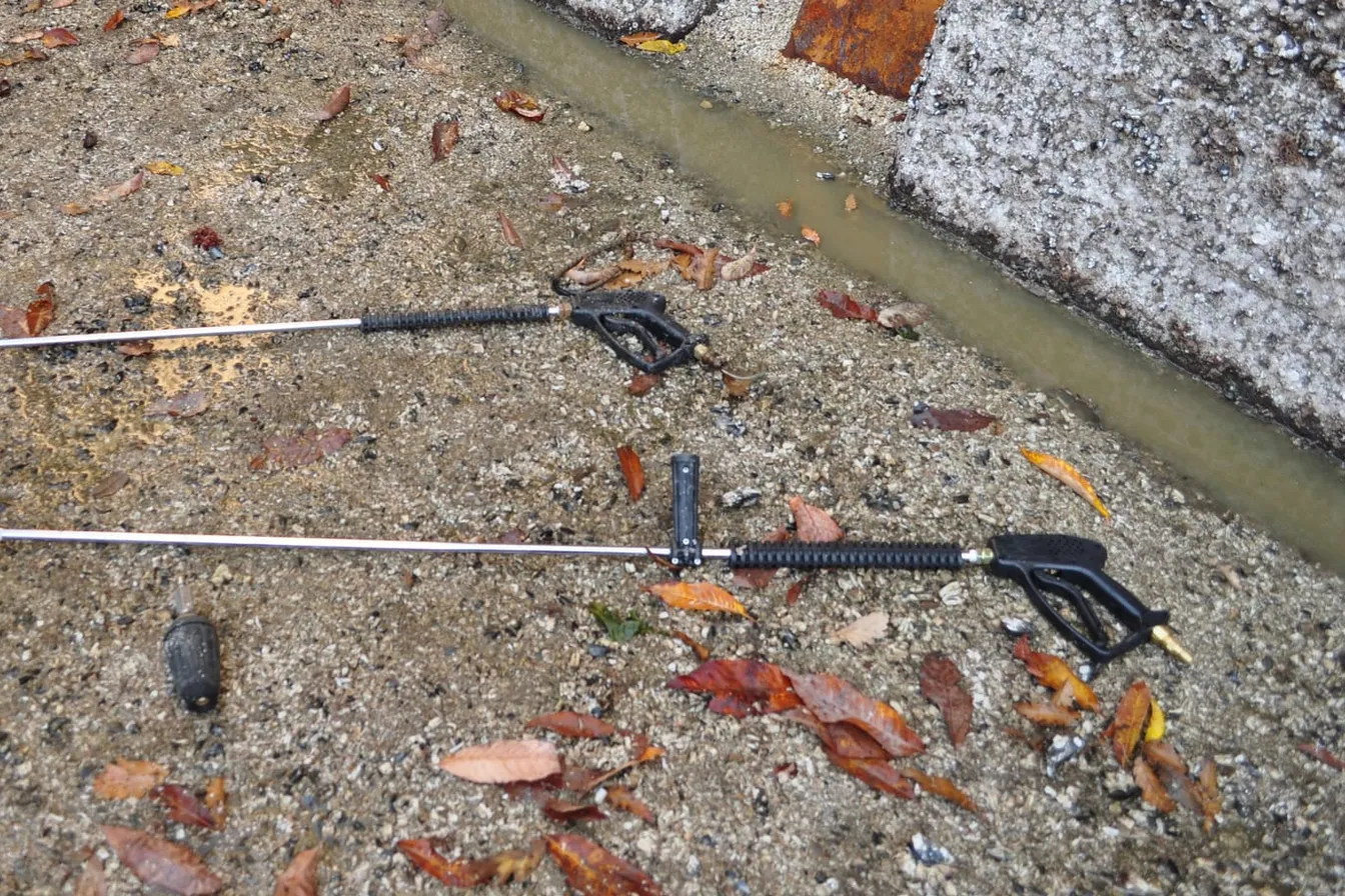 Dos pistolas de hidrolavadora con su lanza y una boquilla turbo sobre el piso