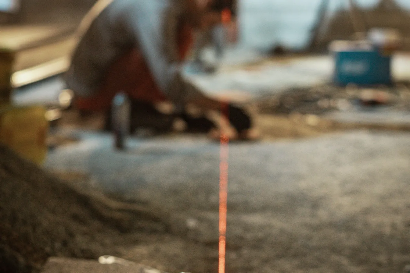 Nivel láser en el piso marcando una línea en una obra