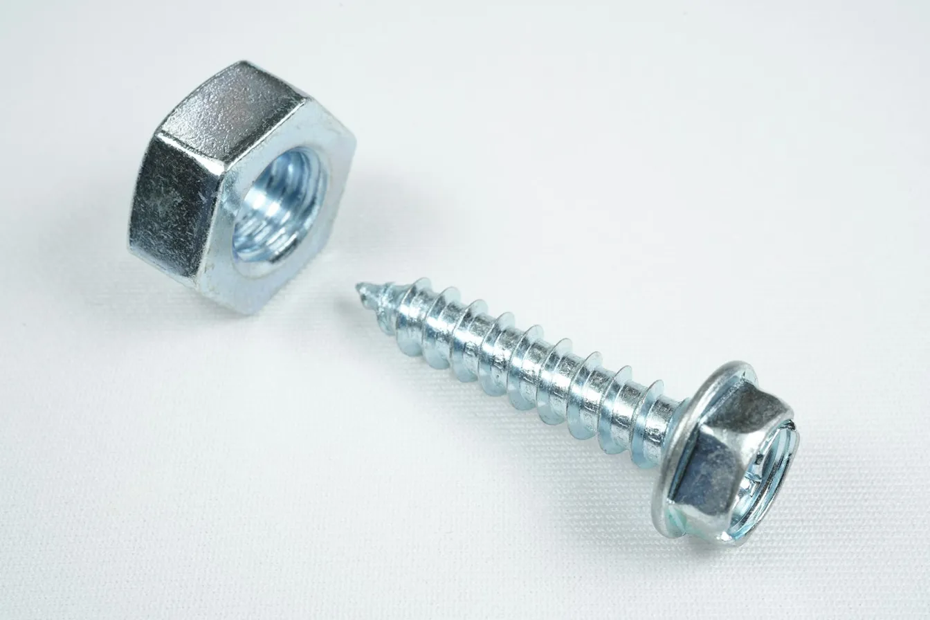 Tornillo plateado sobre una mesa blanca